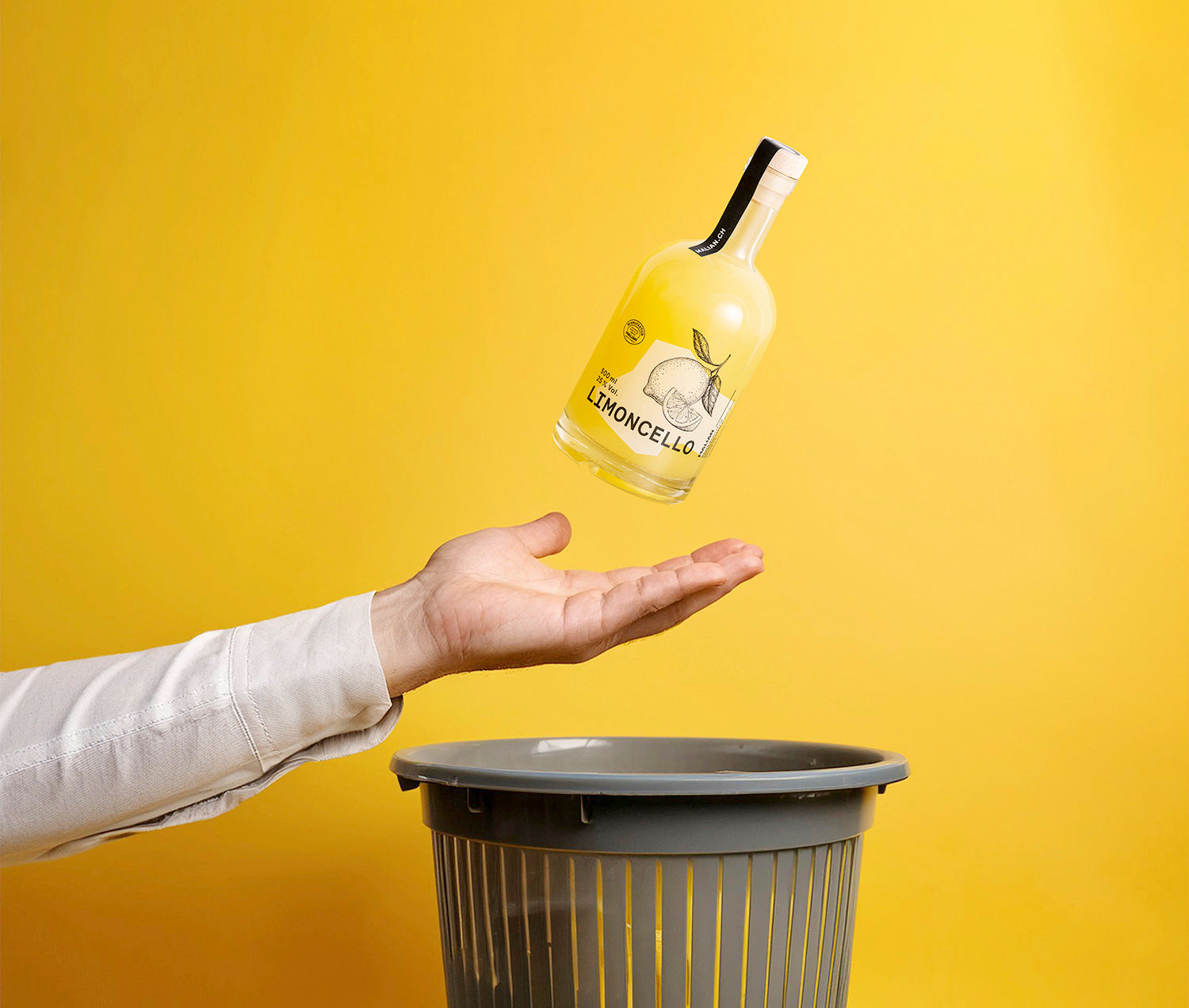 Eine Hand fängt eine Flasche unseres Limoncellos und bewahrt dadurch die darin enthaltenen Zitronen vor dem Abfall.